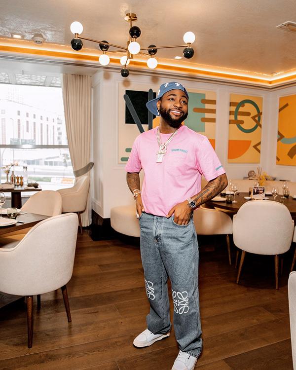 Davido in Pink Tee, Wide-Leg Jeans & Bandana for Dubai Dinner | OutfitLibrary.com