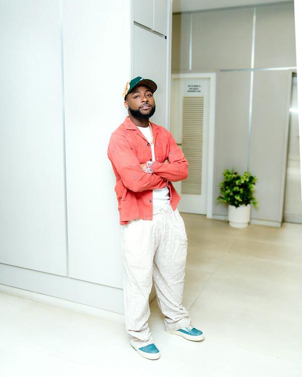 Davido in Coral Overshirt, Cream Trousers & Teal Sneakers Off-Duty Look | OutfitLibrary.com