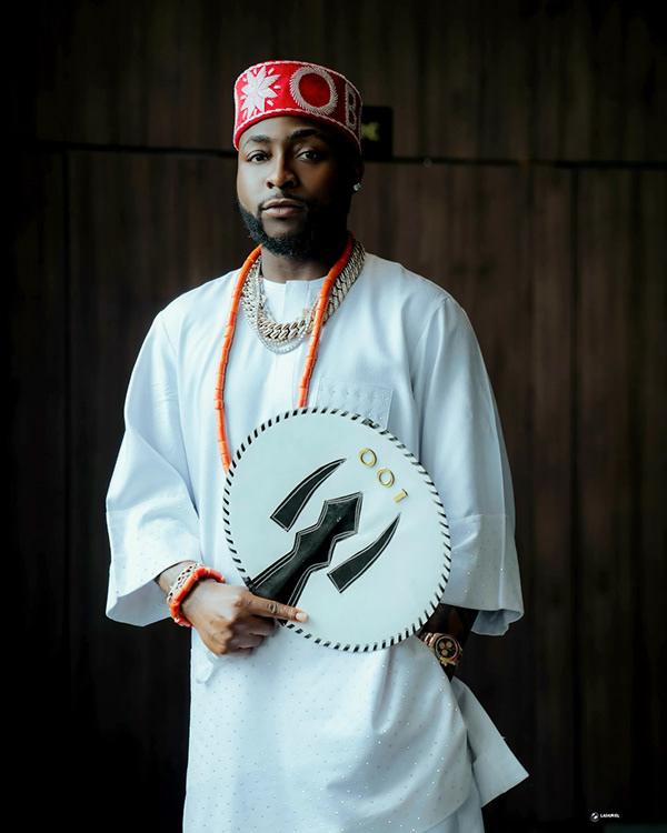 Davido in White Native with Red Cap, Coral Beads & 001 Heritage Fan | OutfitLibrary.com